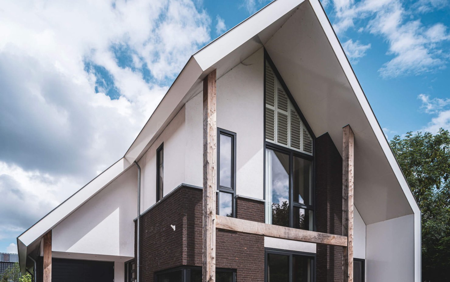 Voorgevel met eikenhouten constructie onder de moderne kap