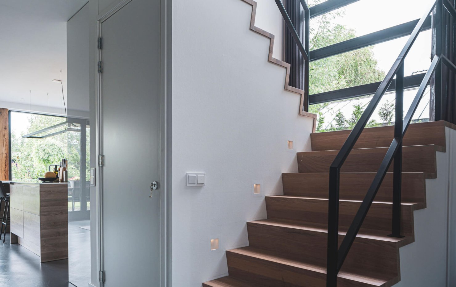 Trap met stalen reling en inbouwspots in de muur