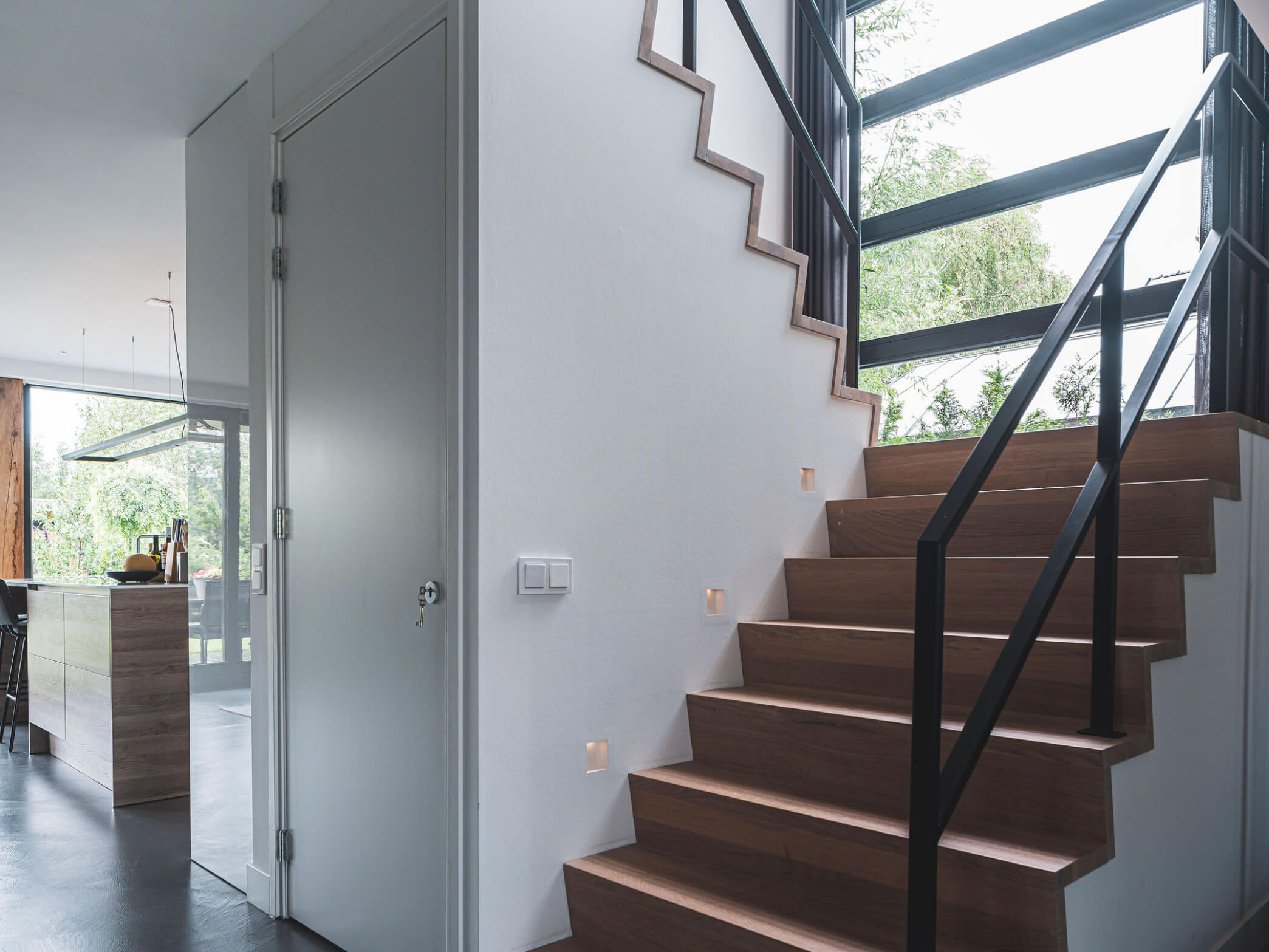 Trap met stalen reling en inbouwspots in de muur