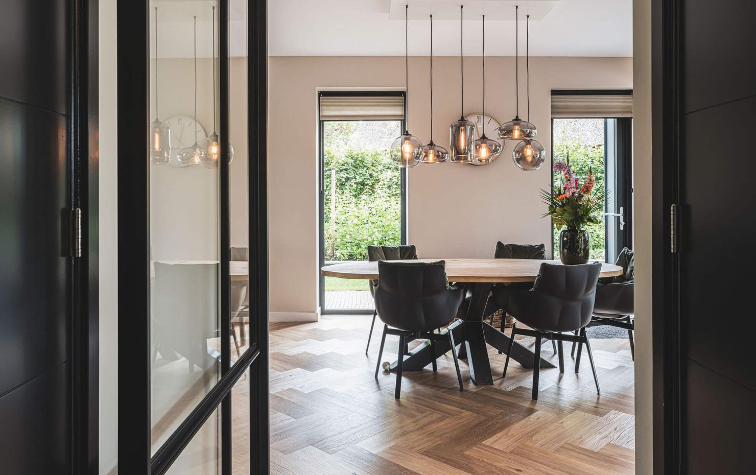 Glazen designlampen boven moderne eethoek