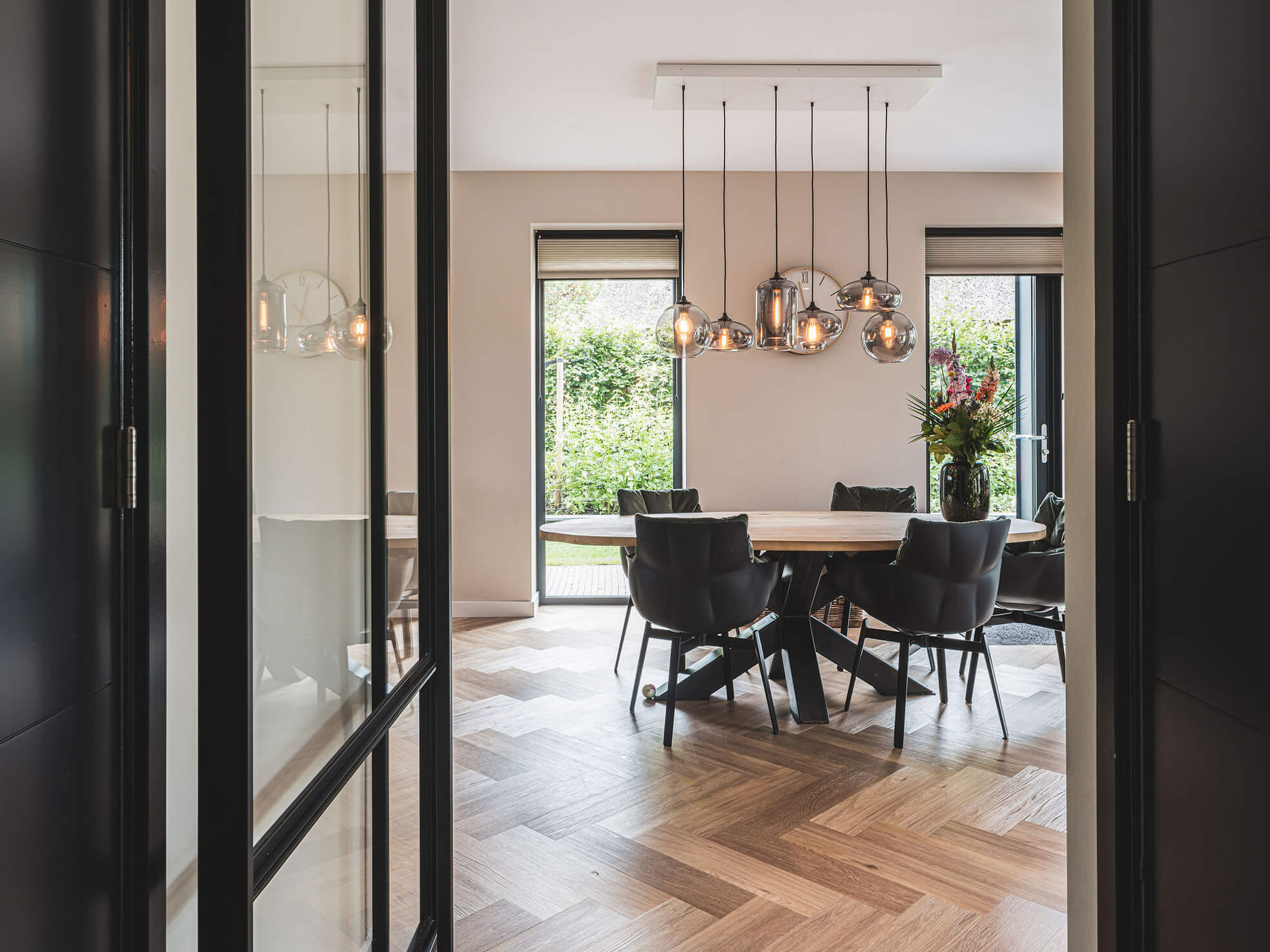 Glazen designlampen boven moderne eethoek