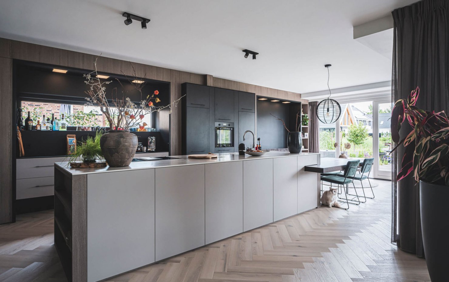 Design keuken met kookeiland en eetbar bij de glazen schuifpui