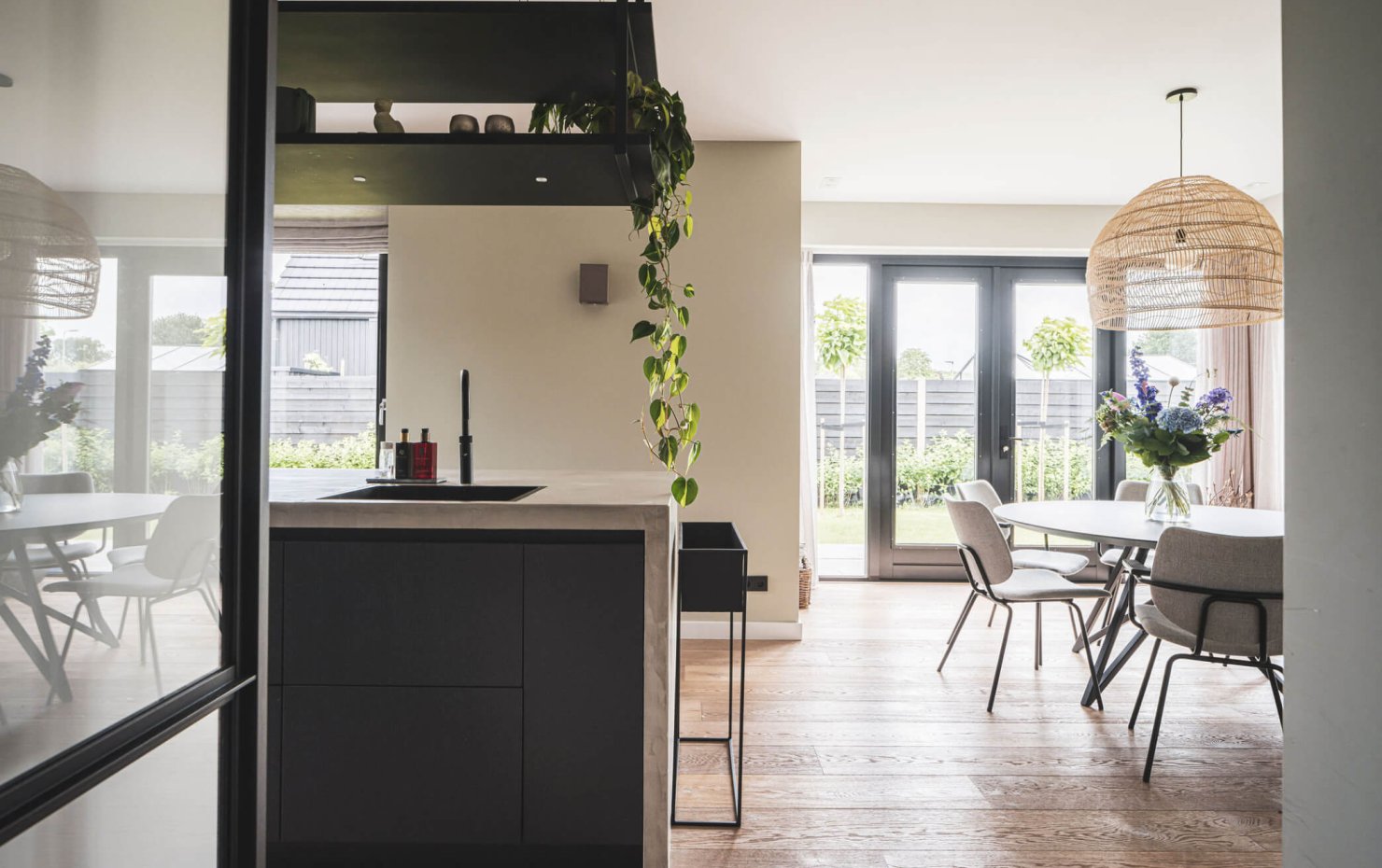 Doorzicht vanuit de keuken naar de dubbele tuindeuren bij de eethoek