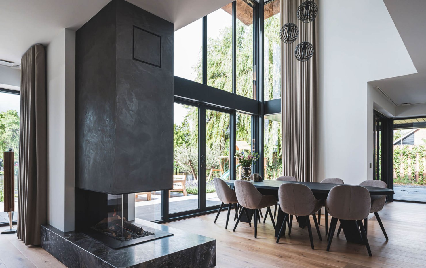 Eetgedeelte van de living met design inbouw openhaard en open vide