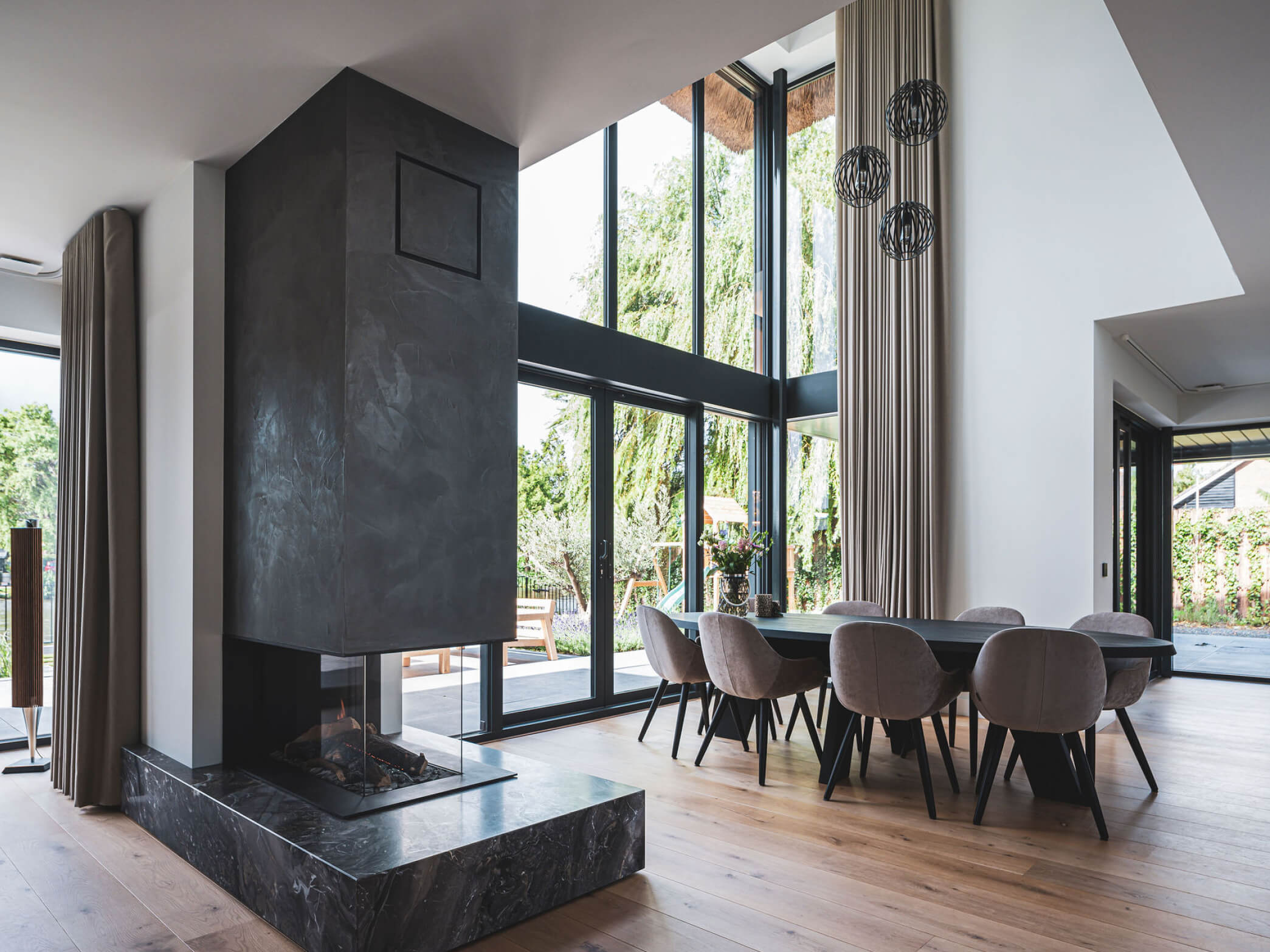 Eetgedeelte van de living met design inbouw openhaard en open vide