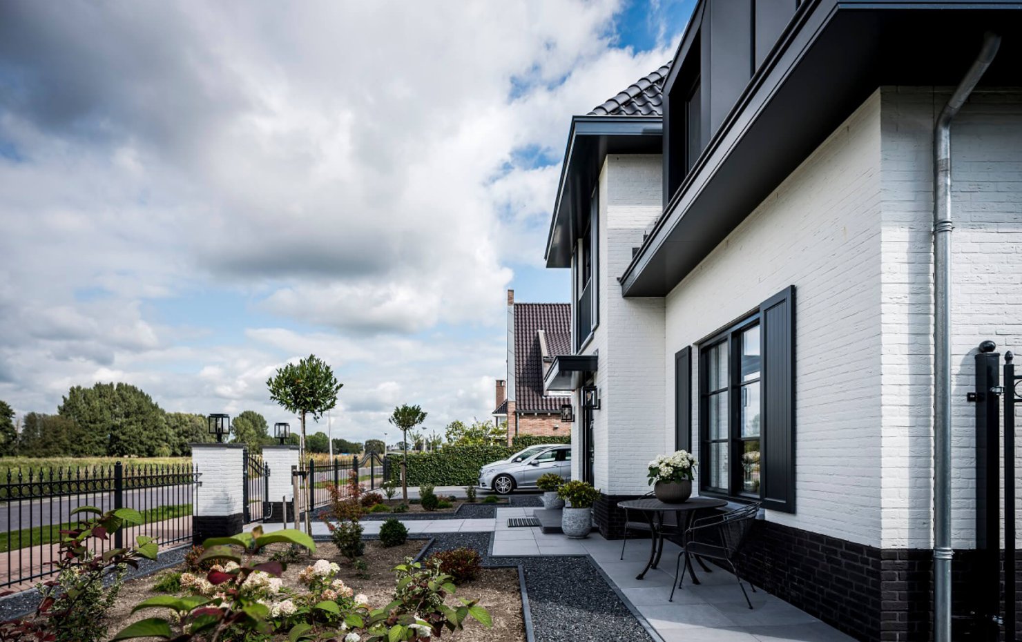 Voorgevel van een notariswoning met dubbele voordeur en luiken bij de ramen