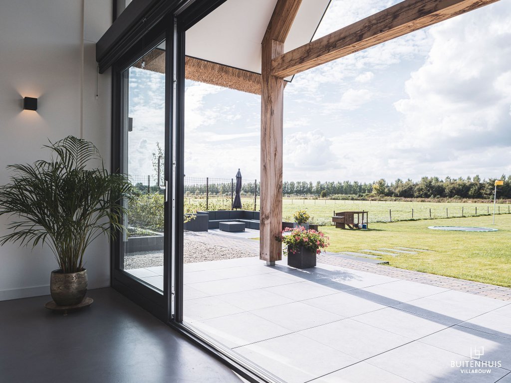 ThumbnailUitzicht vanaf terras van een landelijke villa met houten balken onder de overkapping van de veranda