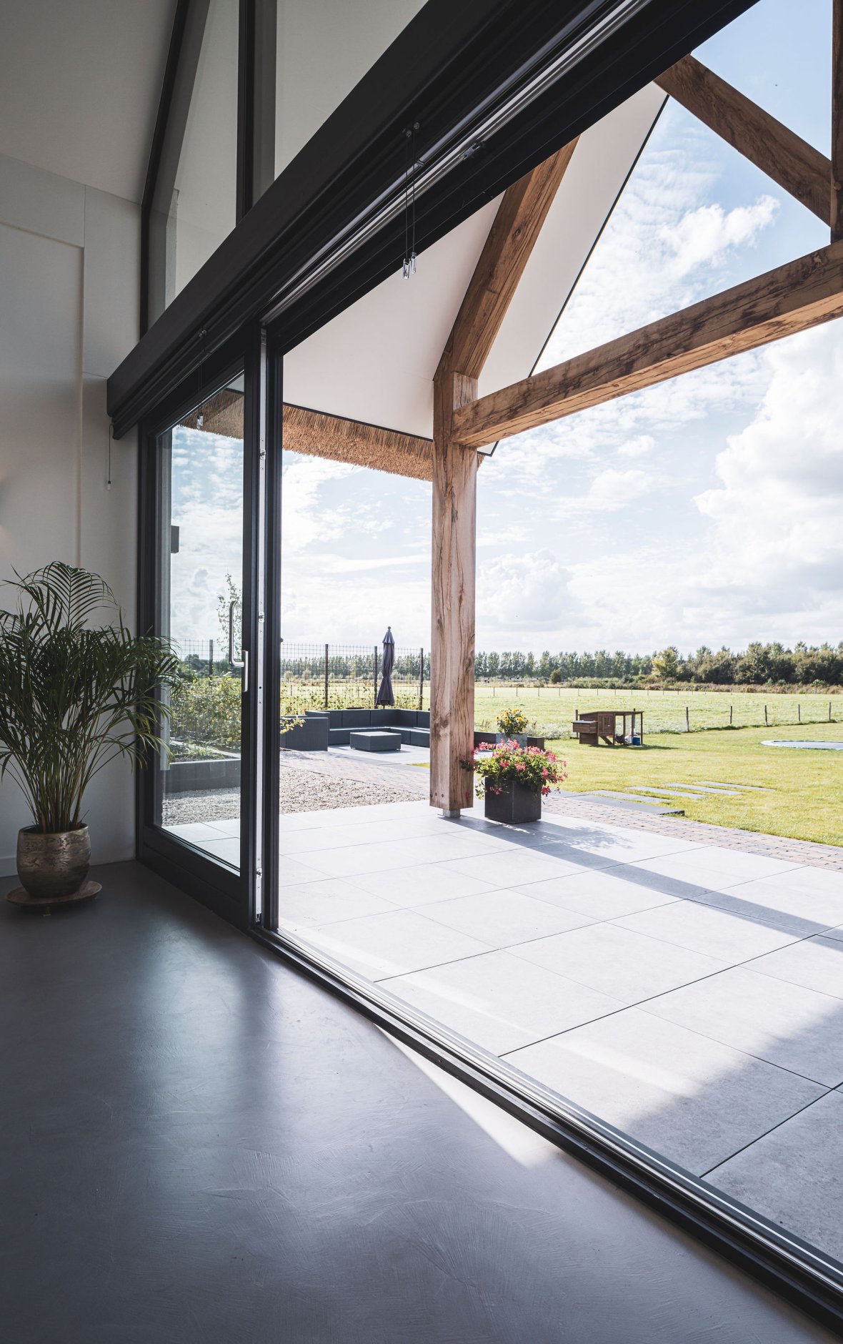 Uitzicht vanaf terras van een landelijke villa met houten balken onder de overkapping van de veranda