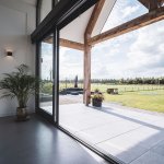 ThumbnailUitzicht vanaf terras van een landelijke villa met houten balken onder de overkapping van de veranda