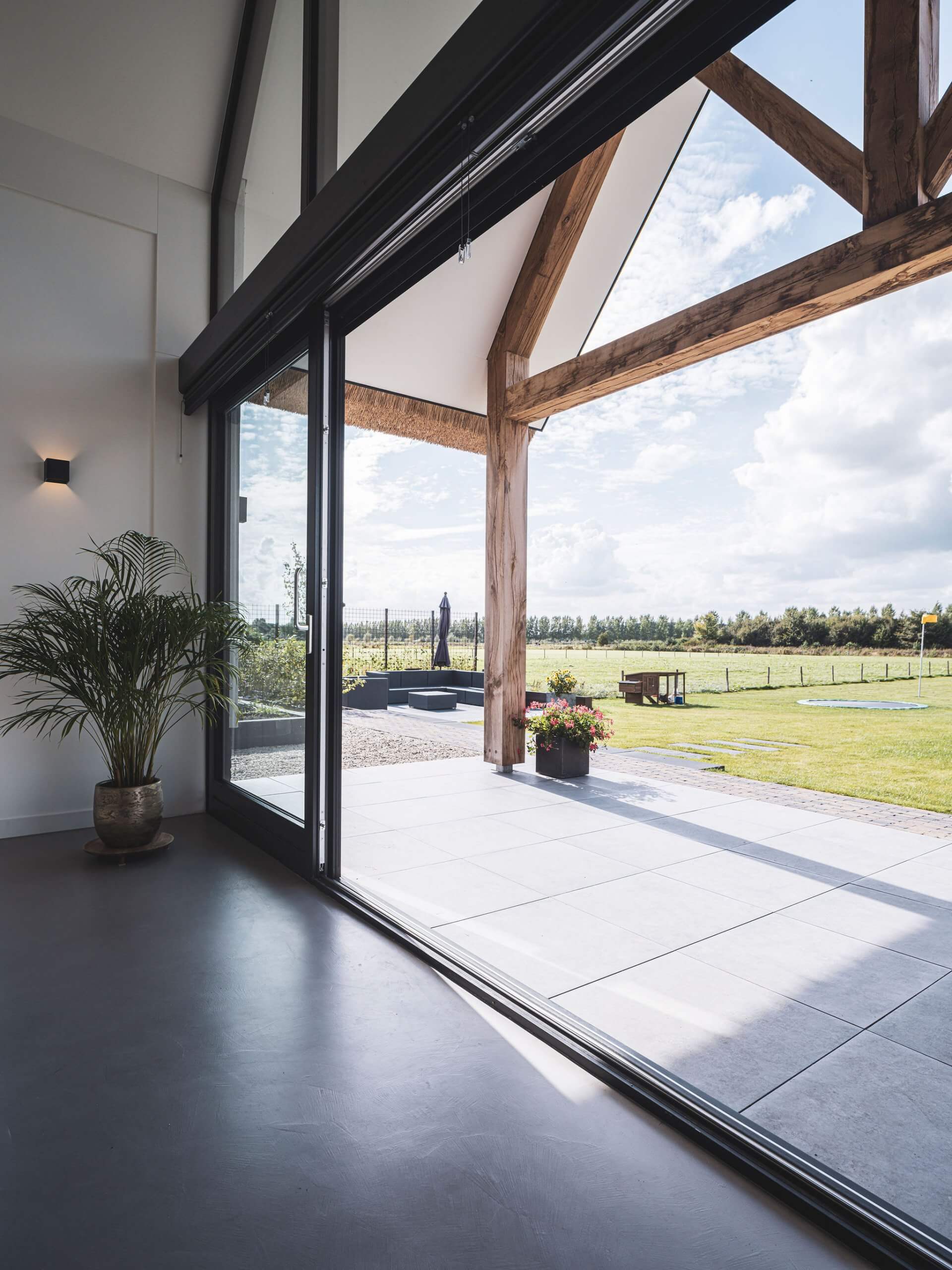 Uitzicht vanaf terras van een landelijke villa met houten balken onder de overkapping van de veranda