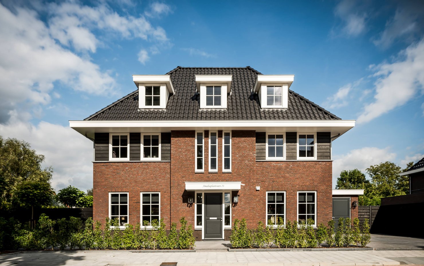 Voorgevel herenhuis met symmetrische opbouw en drie dakkappellen