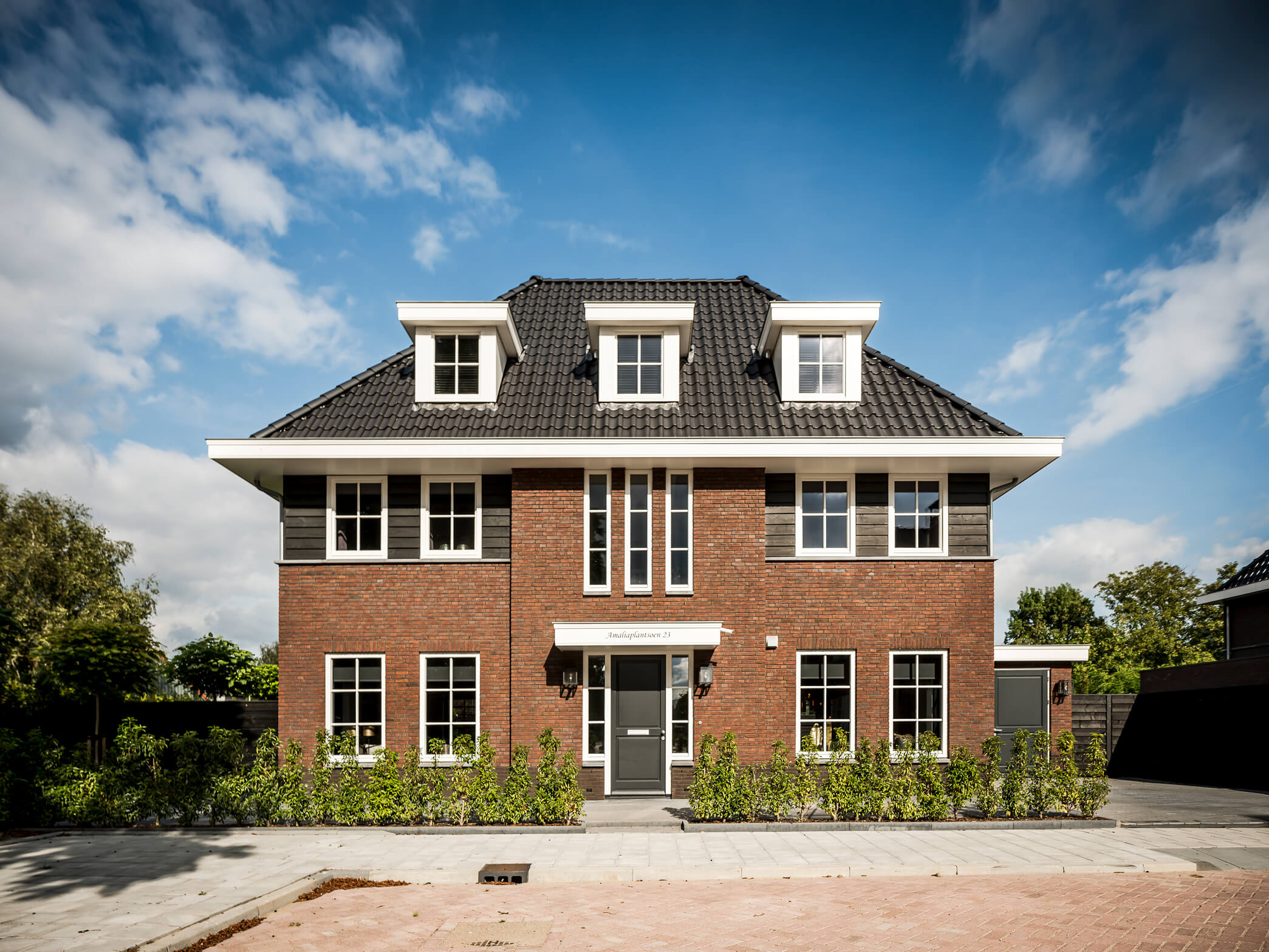 Voorgevel herenhuis met symmetrische opbouw en drie dakkappellen