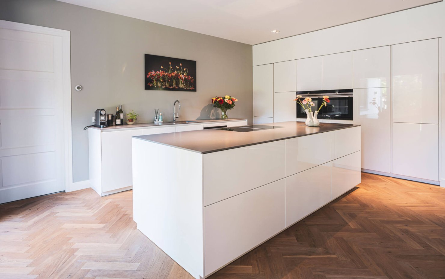 Strakke designkeuken met greeploze hoogglans witte kasten
