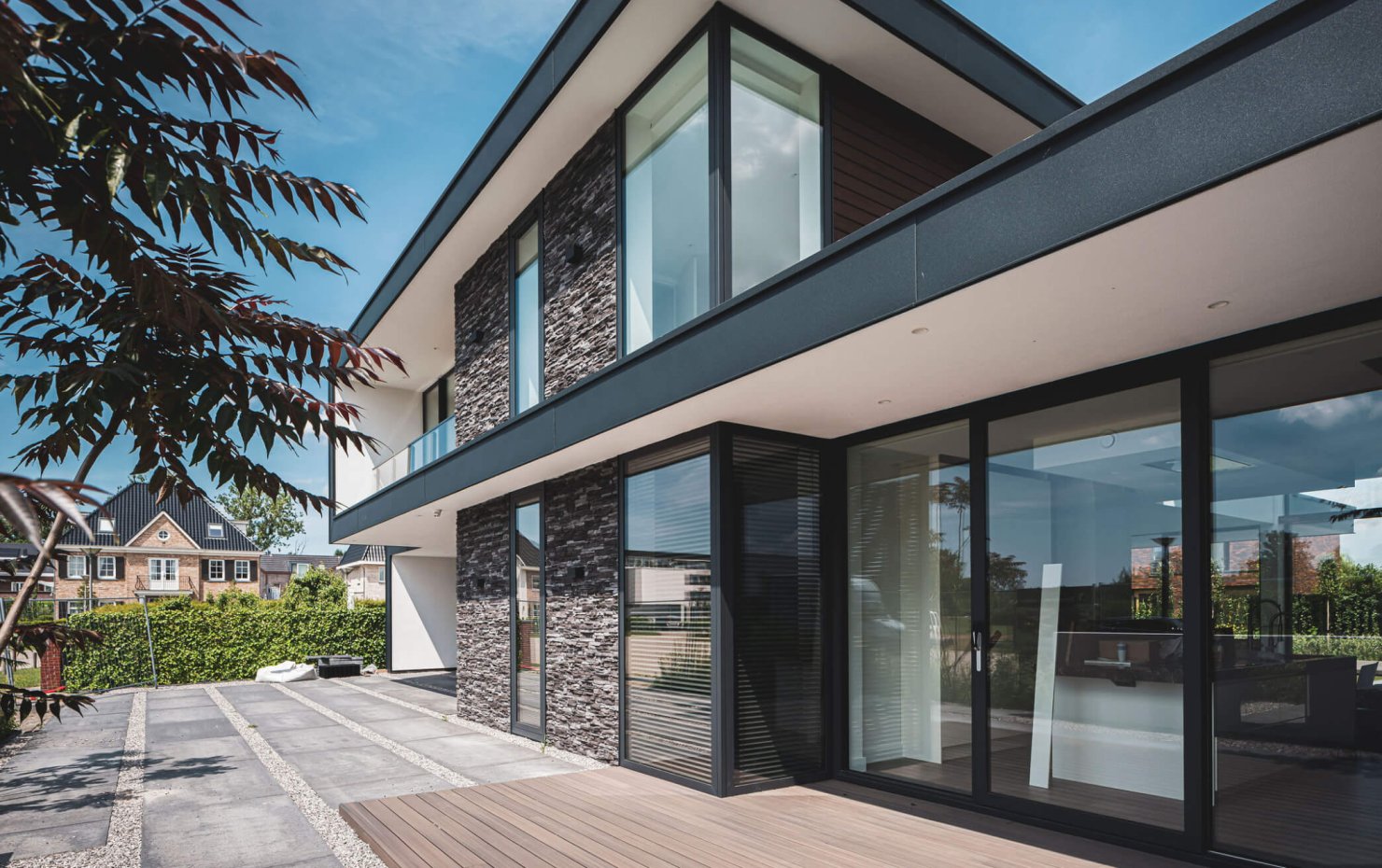 Moderne kubistische woning met grote raampartijen, staal hout en siersteen