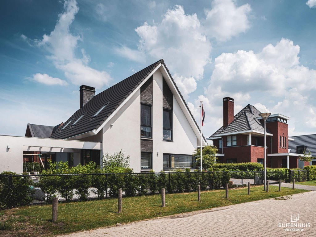 ThumbnailModerne woning met witte gevel, donkere baksteen accenten en zonneterras met lamellen