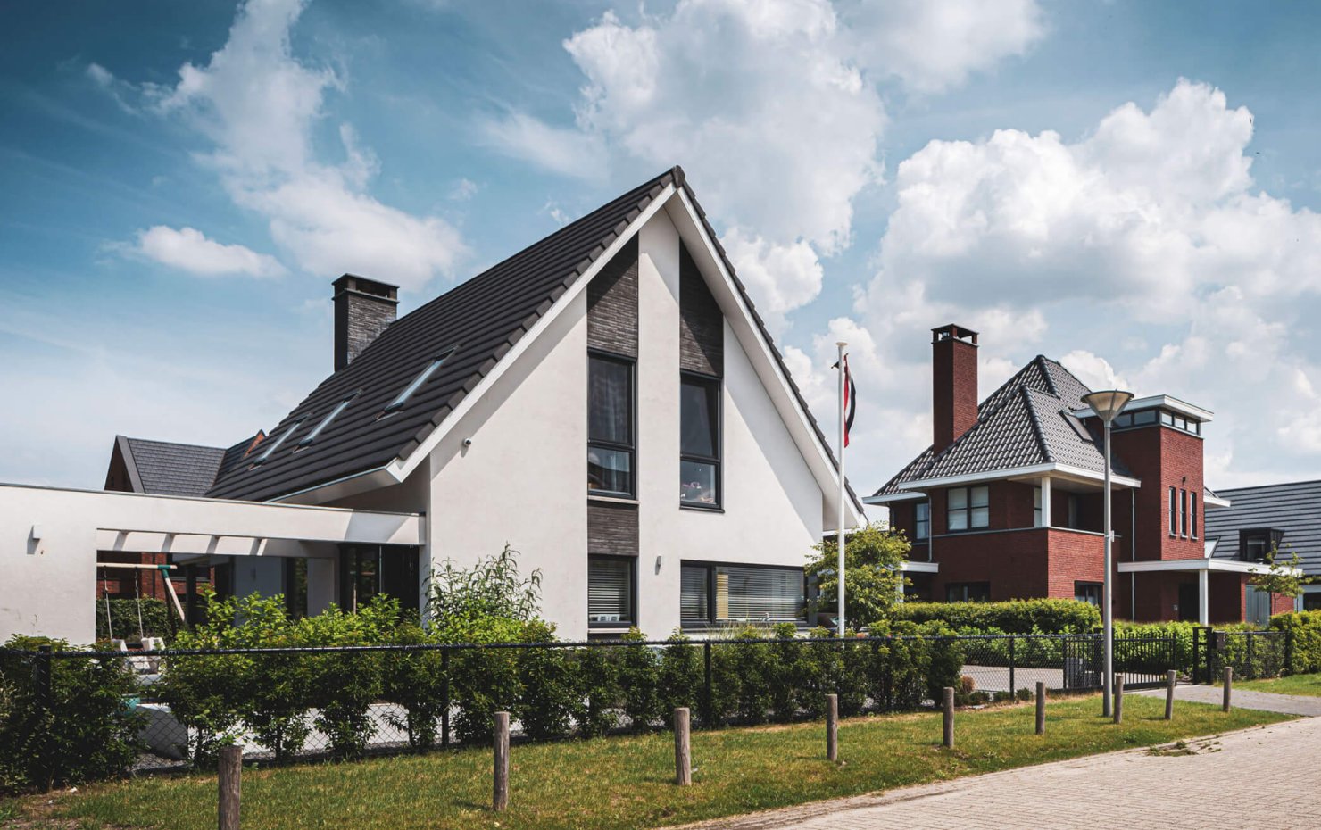 Moderne woning met witte gevel, donkere baksteen accenten en zonneterras met lamellen