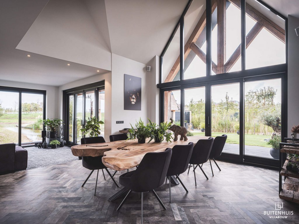 Thumbnail Interieur landelijke villa met bijna volledig glazen gevel en eiken spant onder veranda