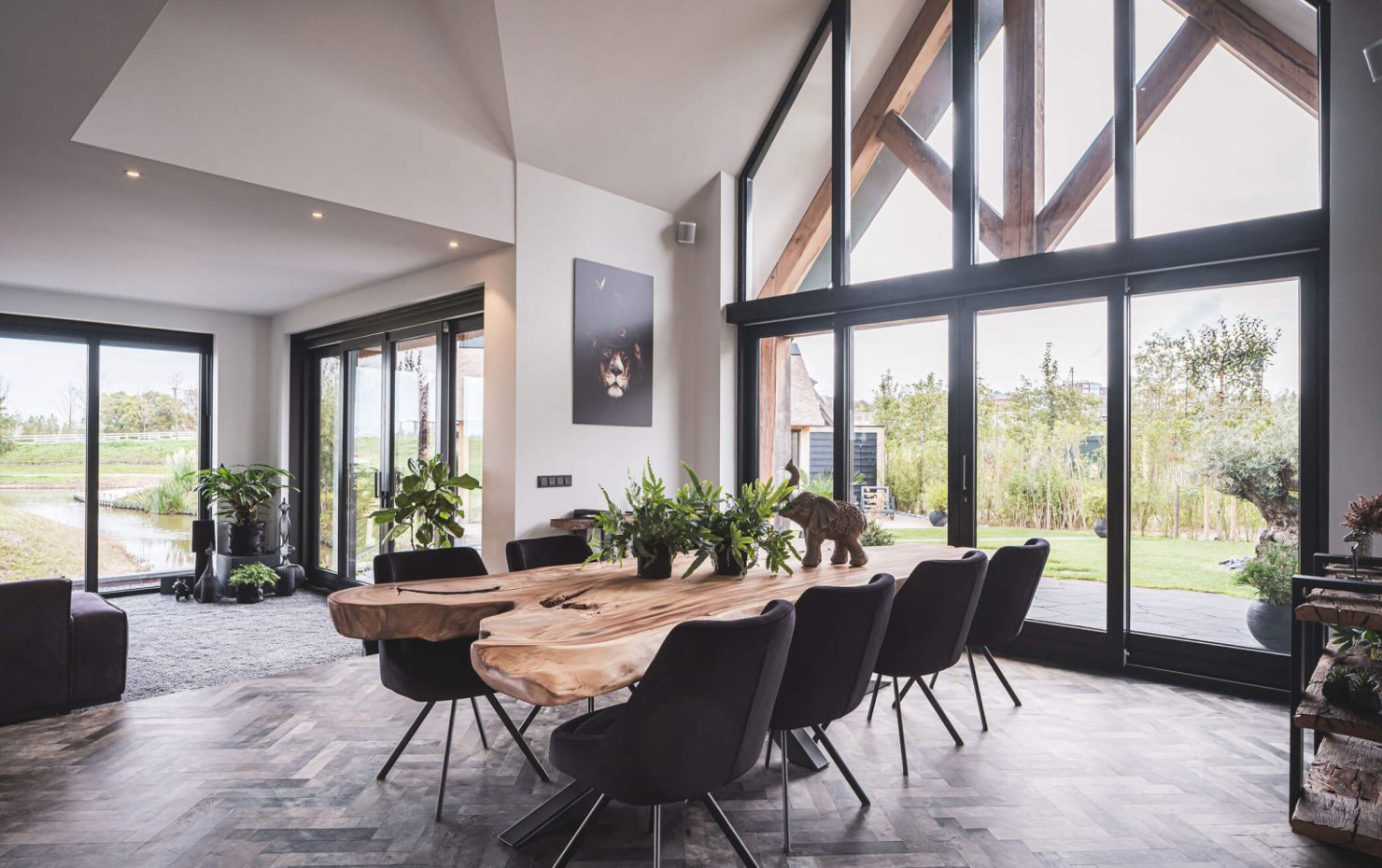 Interieur landelijke villa met bijna volledig glazen gevel en eiken spant onder veranda