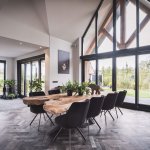 Thumbnail Interieur landelijke villa met bijna volledig glazen gevel en eiken spant onder veranda