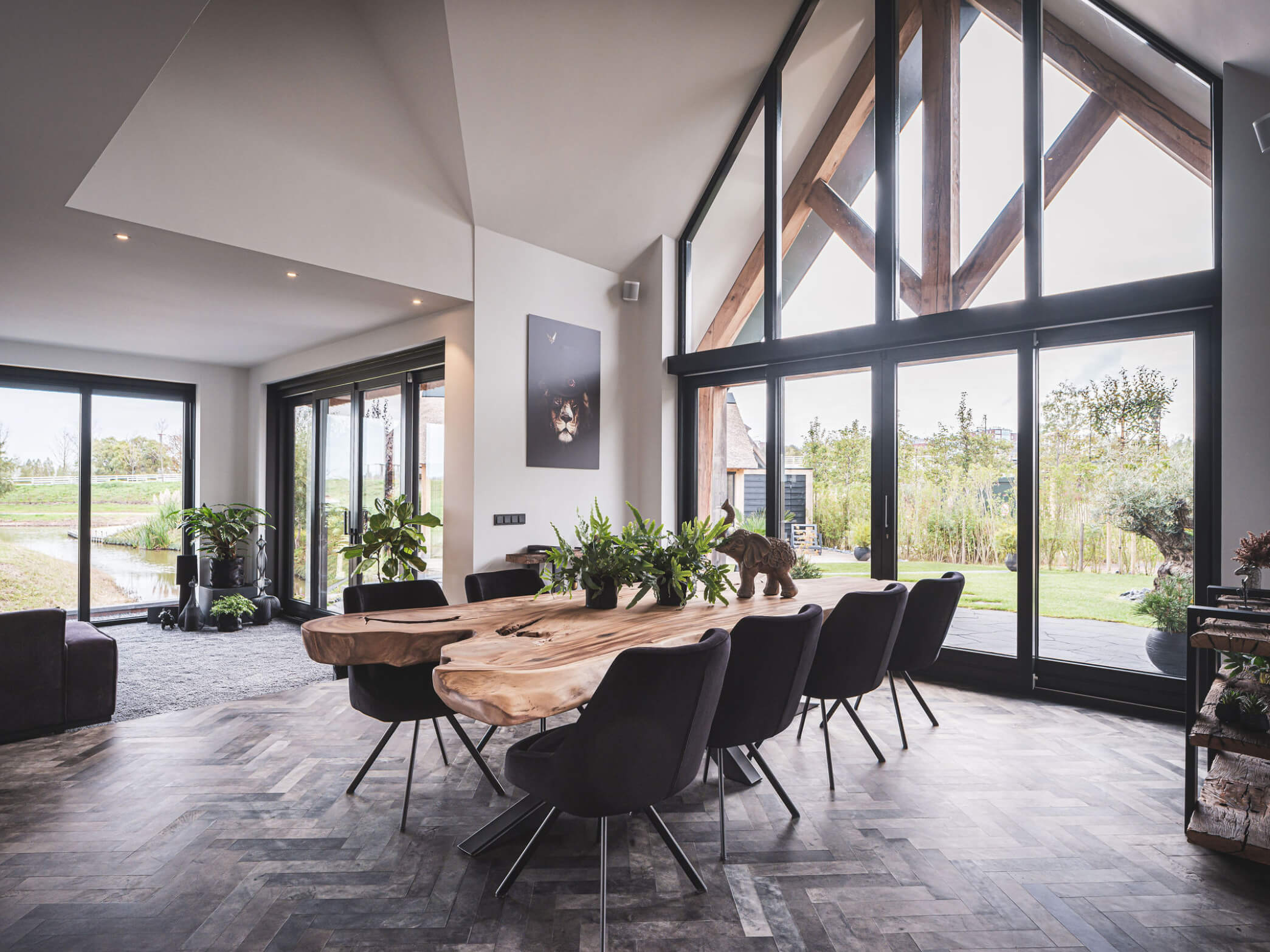 Interieur landelijke villa met bijna volledig glazen gevel en eiken spant onder veranda