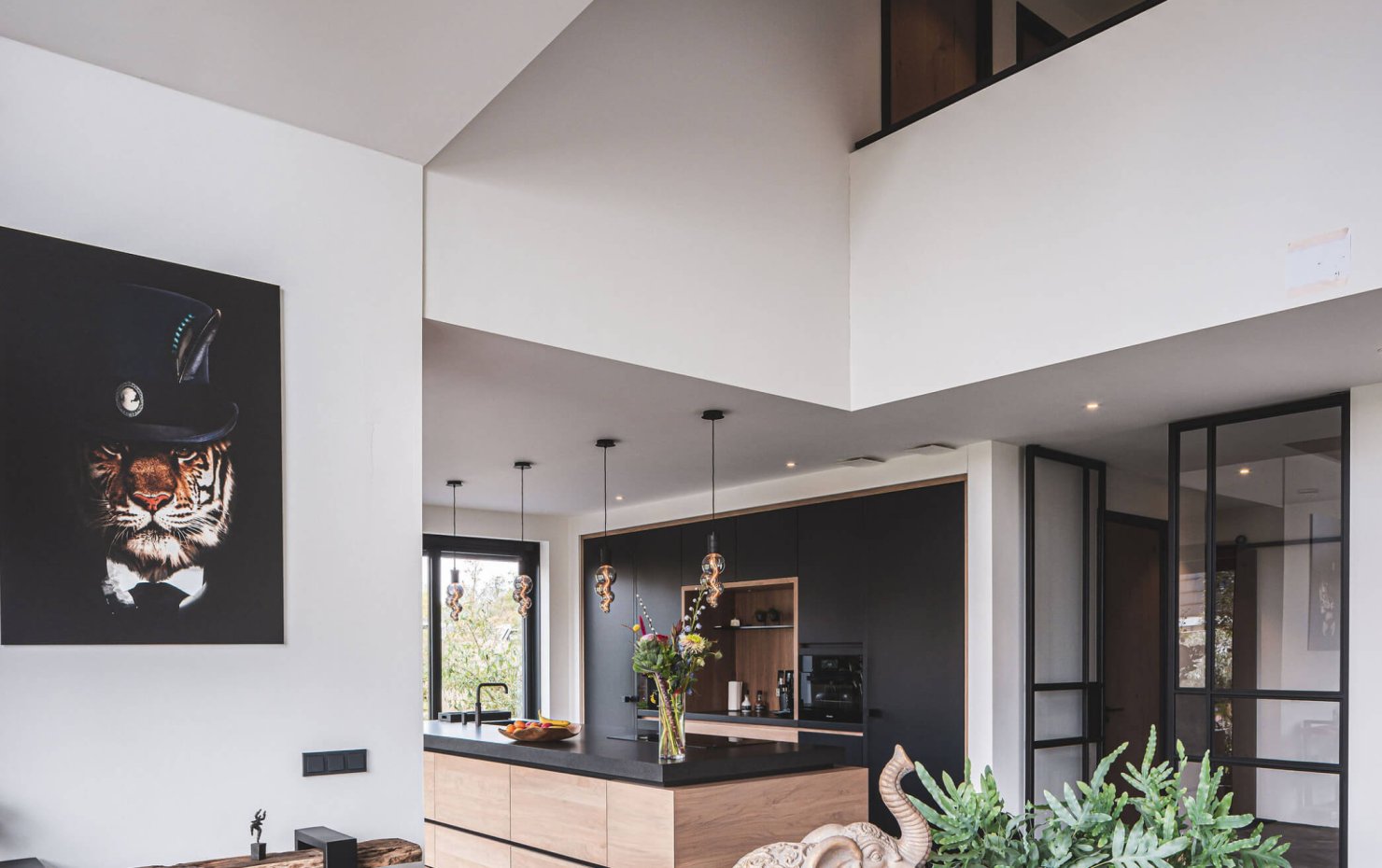 Blik op de vide vanaf de eethoek met de design keuken op de achtergrond