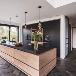 Thumbnail Zwarte design keuken met kookeiland en houten greeploze kastdeuren
