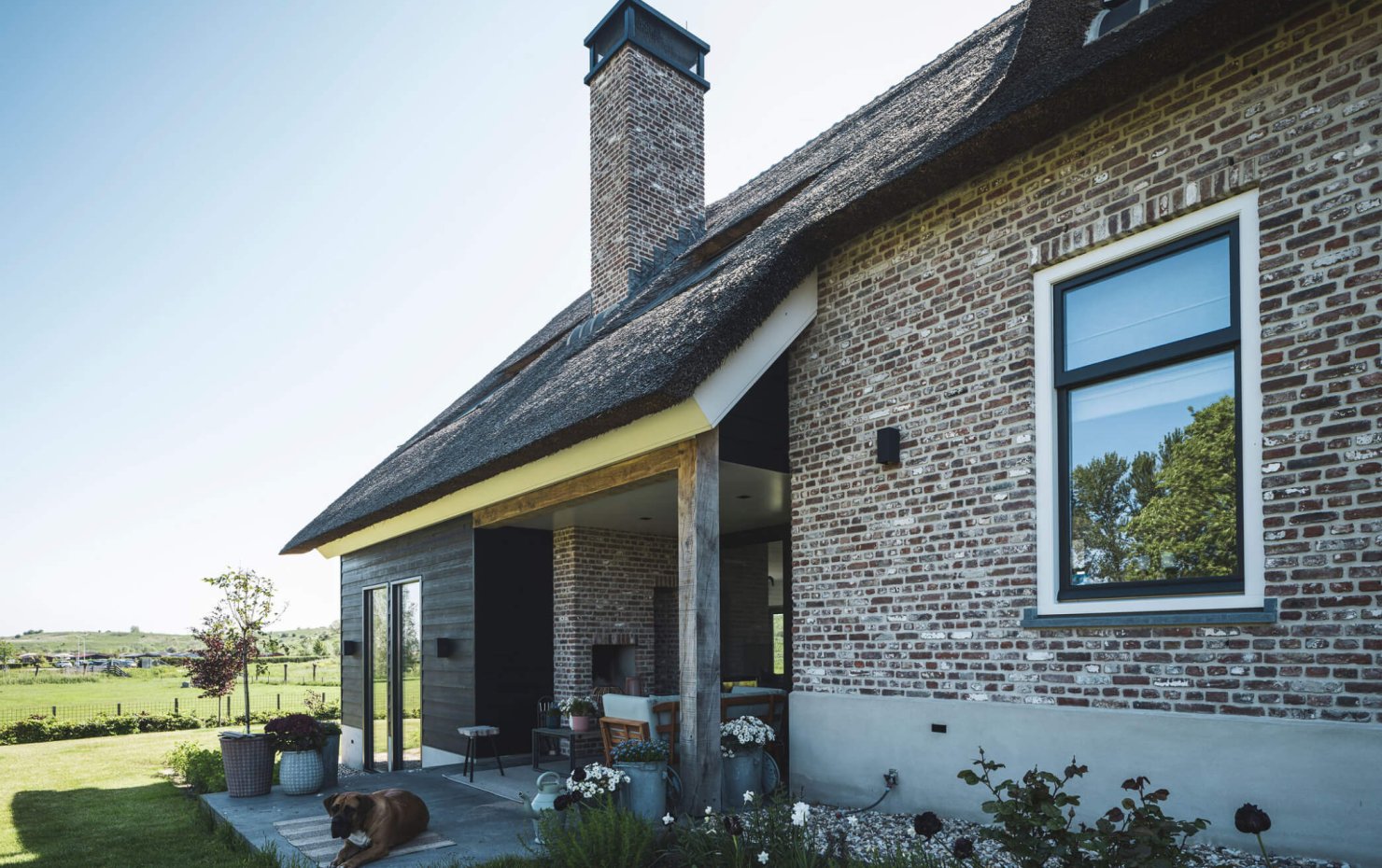 Buitenliving bij klassieke woonboerderij met rieten kap