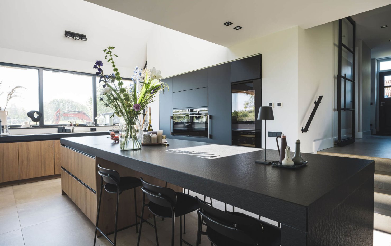 Zwarte design woonkeuken met greeploze houten kastdeuren