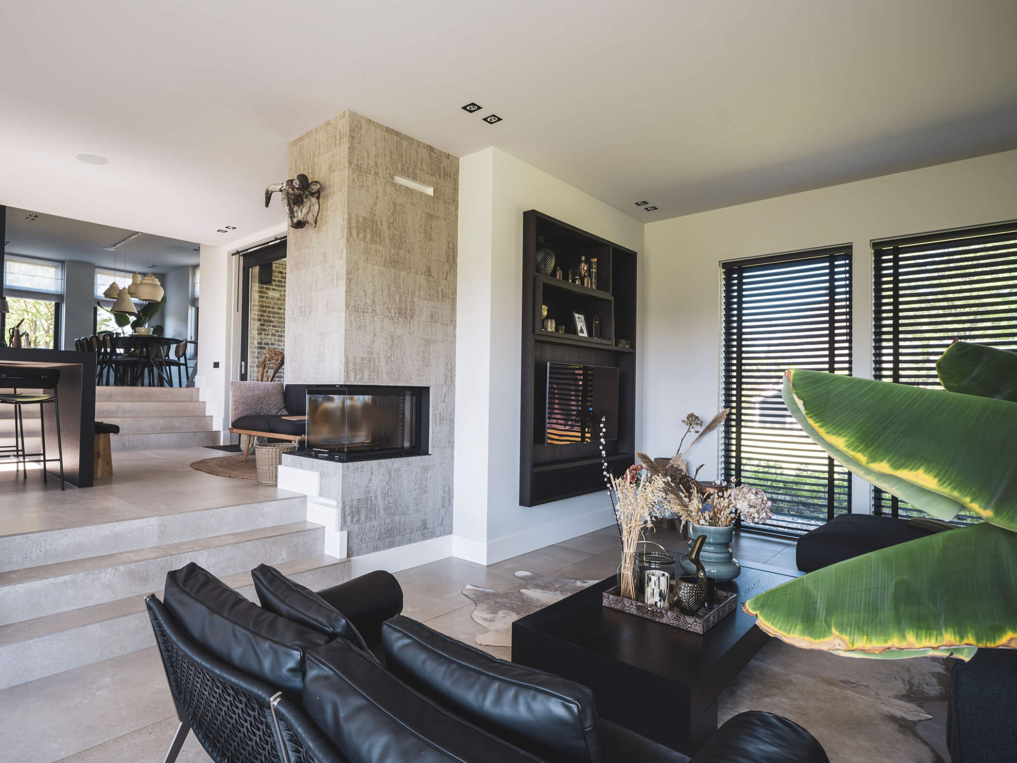 Living met keuken, eetkamer en loungehoek op drie woonniveaus, via trappen verbonden