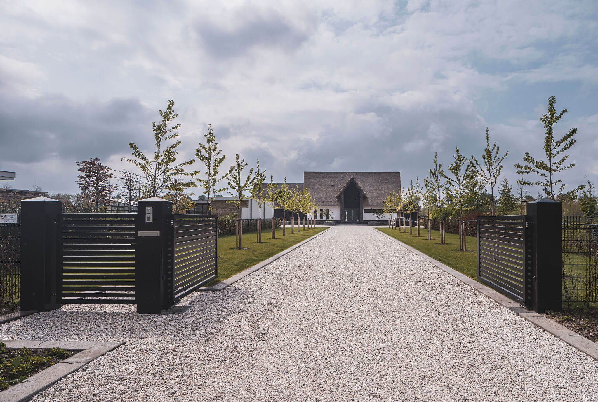 Lange oprit bij landhuis met rieten kap