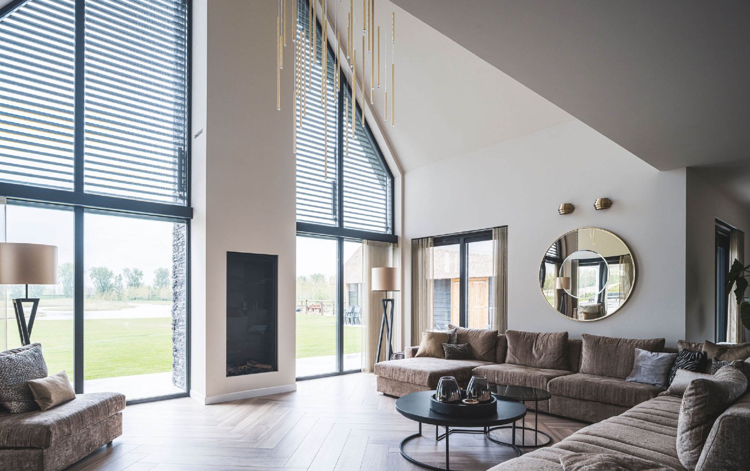 Living villa met rieten kap met uitzicht op achtertuin door glazen achtergevel