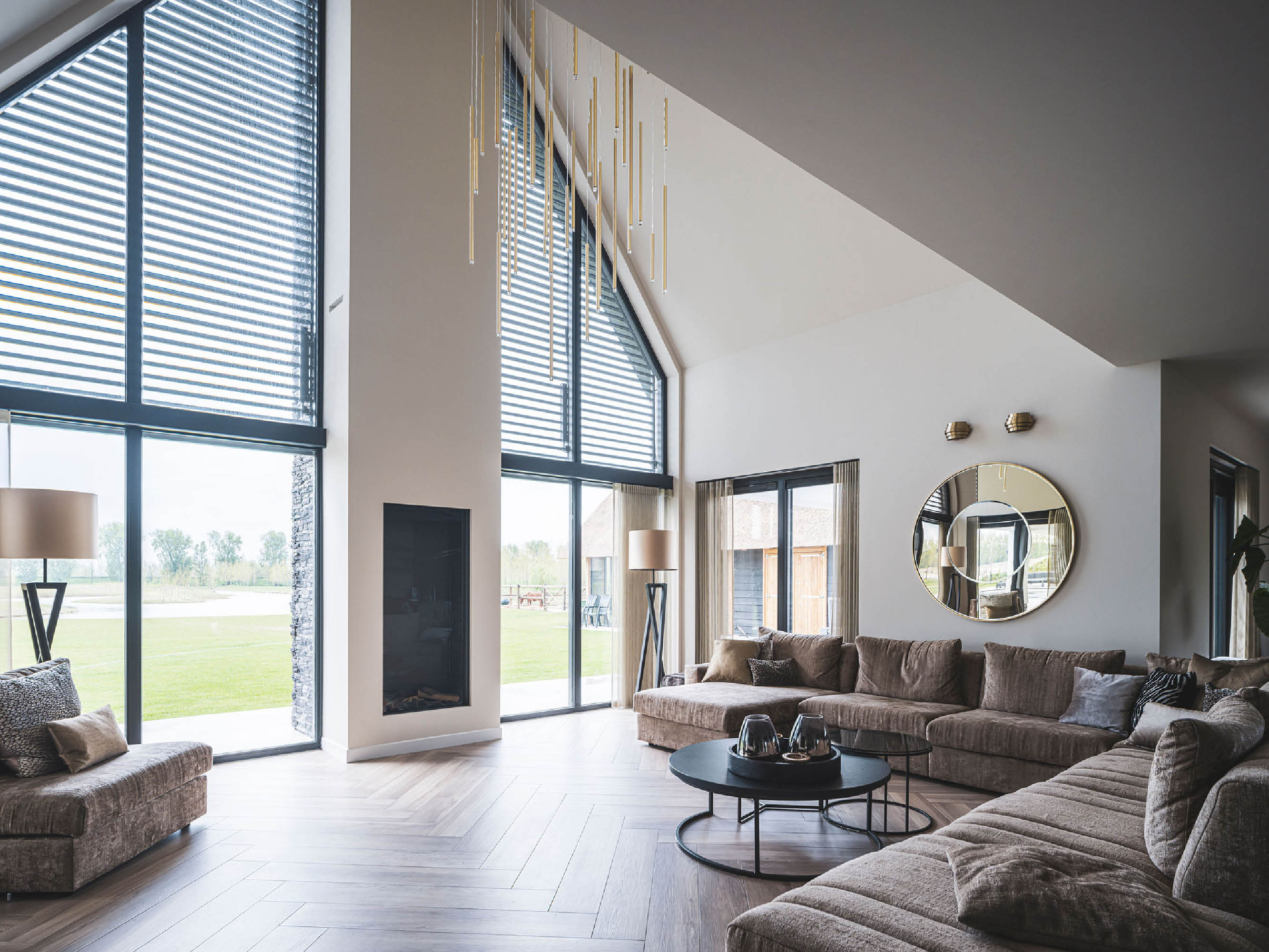 Living villa met rieten kap met uitzicht op achtertuin door glazen achtergevel