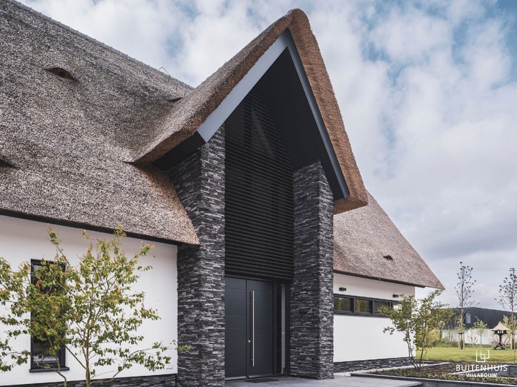 Thumbnail Indrukwekkende entree van villa met rieten dak met bijzondere materialen