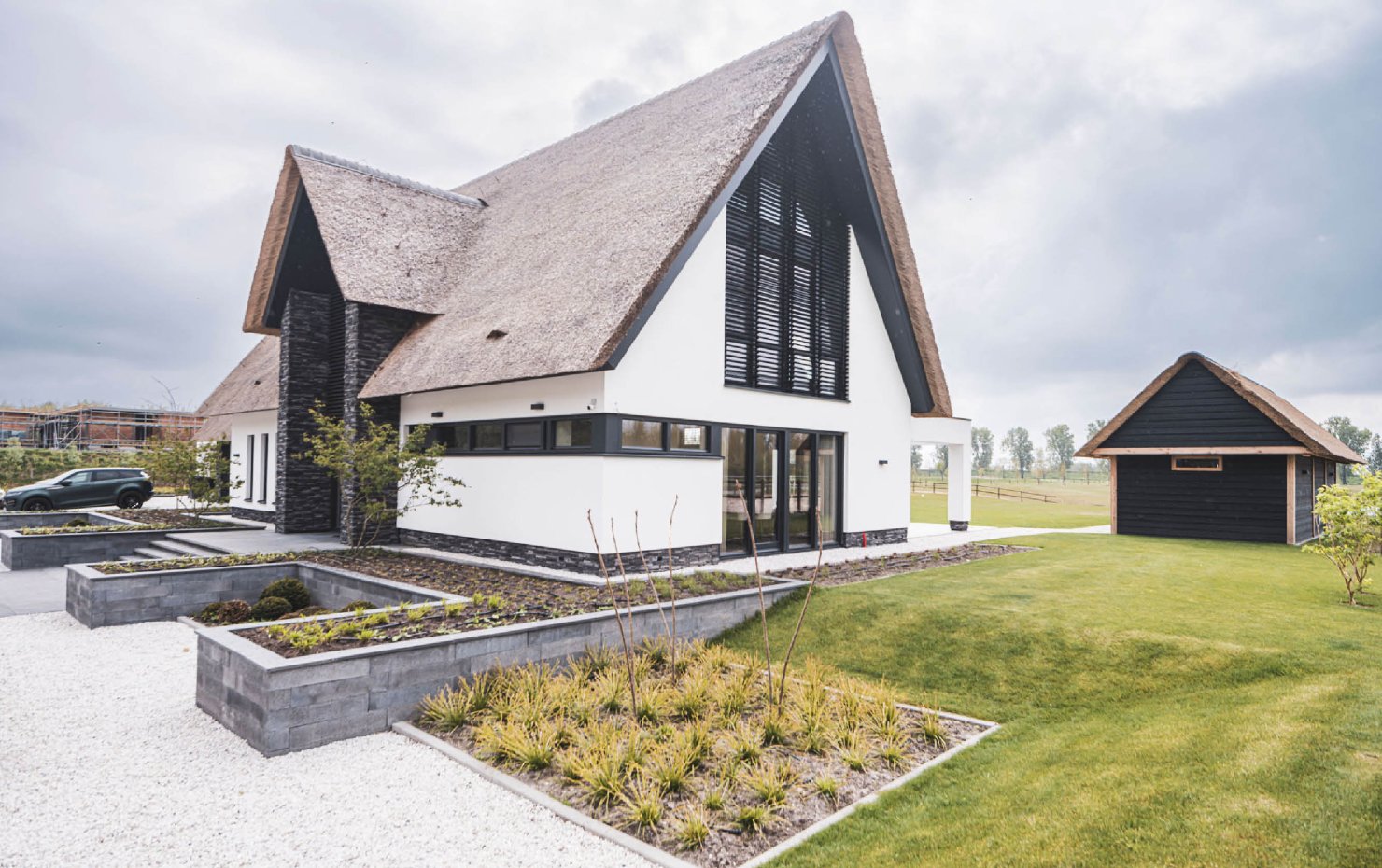 Achtergevel design villa met rieten kap en witgestucte gevel