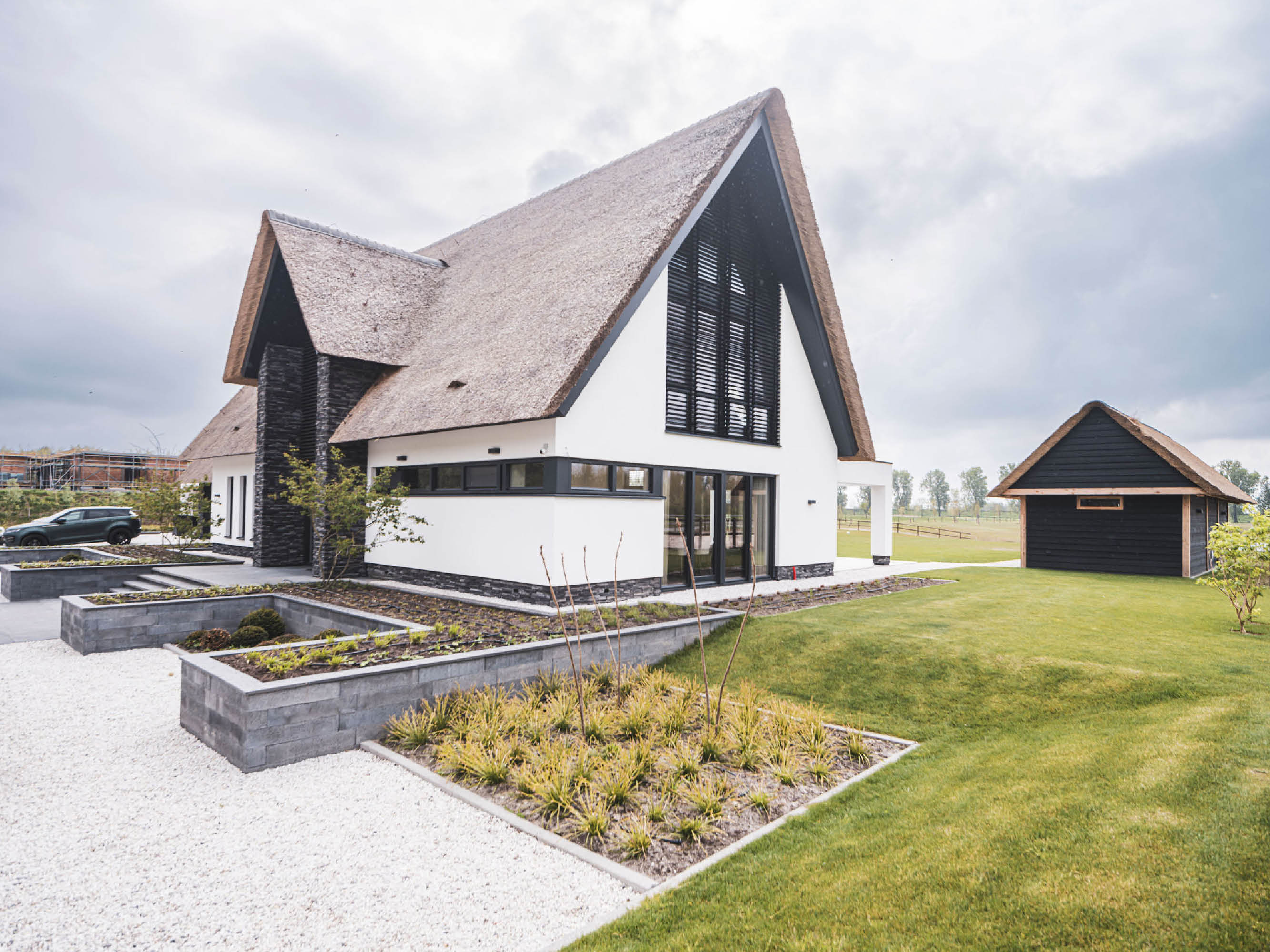 Achtergevel design villa met rieten kap en witgestucte gevel