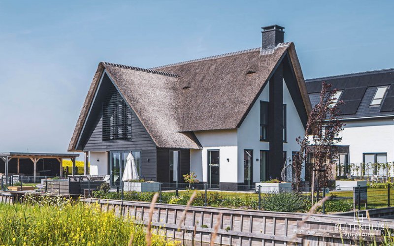 Moderne rietgedekte villa aan het water