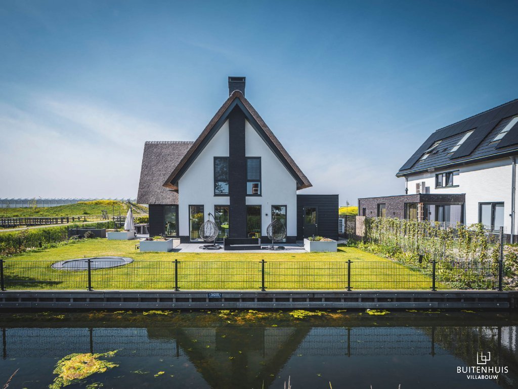 ThumbnailAanzicht vanaf het water van en moderne villa met rieten kap