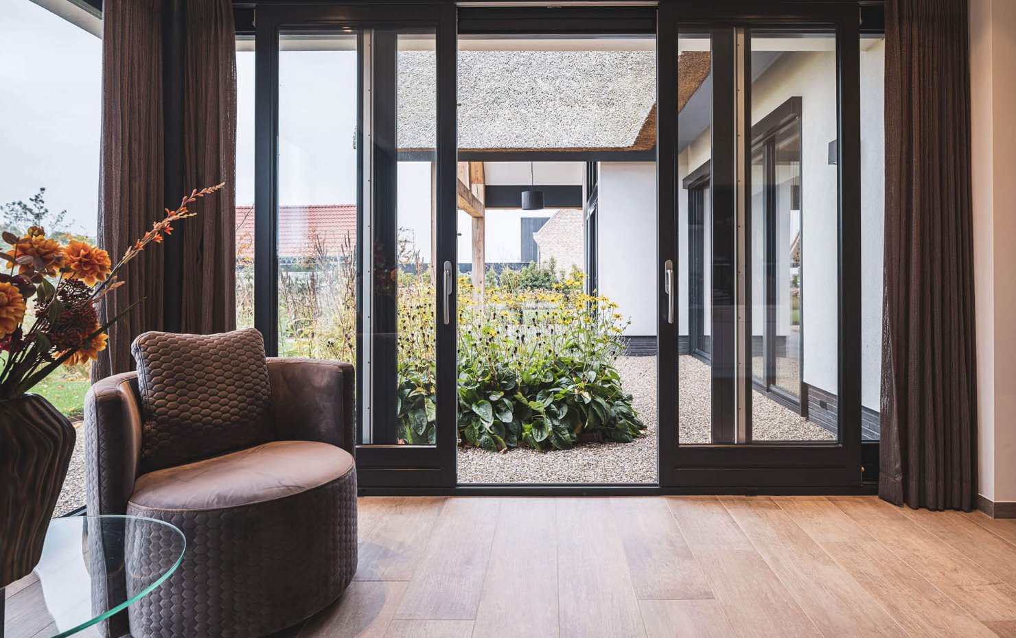 Modern warm interieur met zwarte openstaande schuifpui