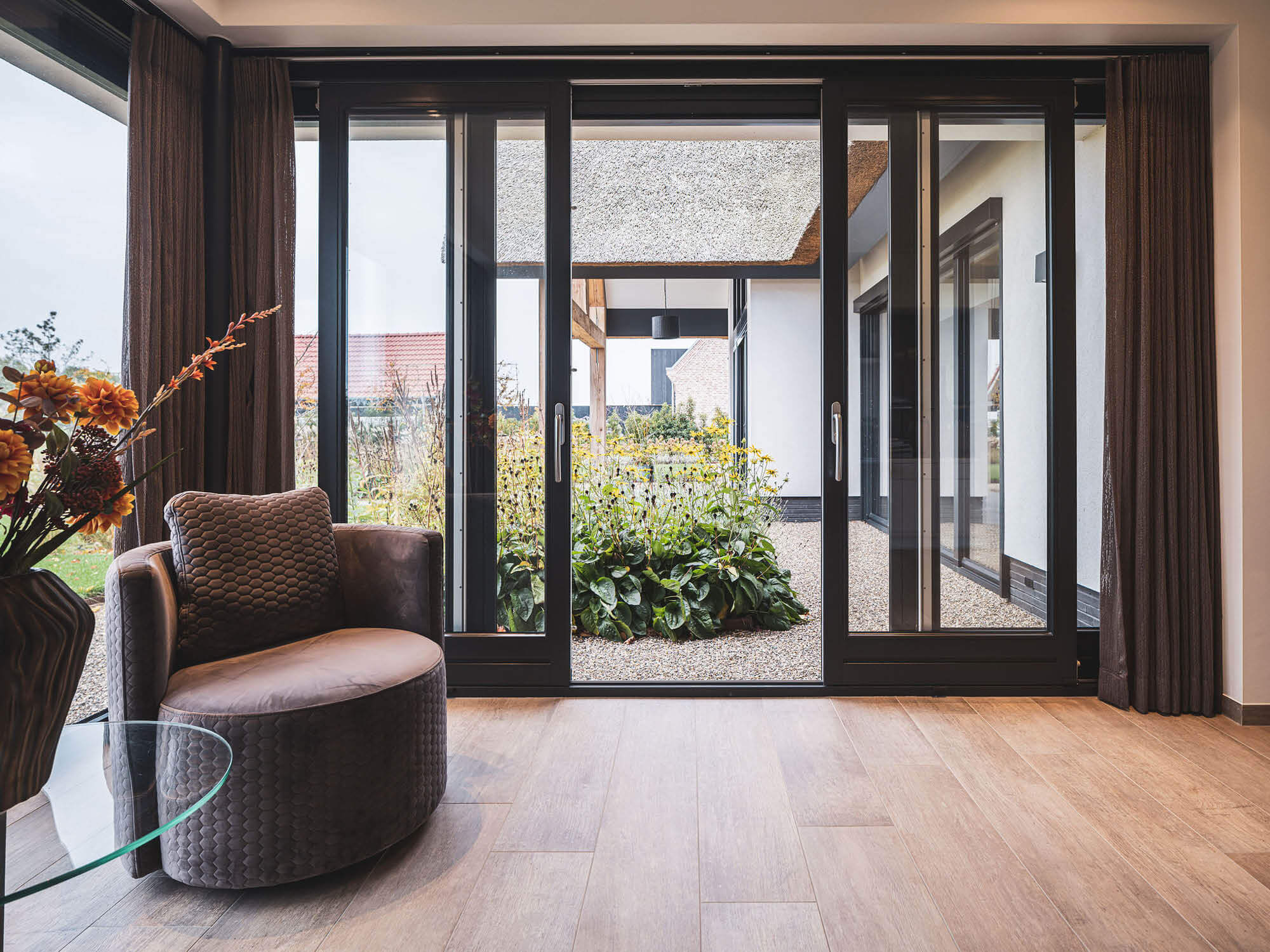 Modern warm interieur met zwarte openstaande schuifpui