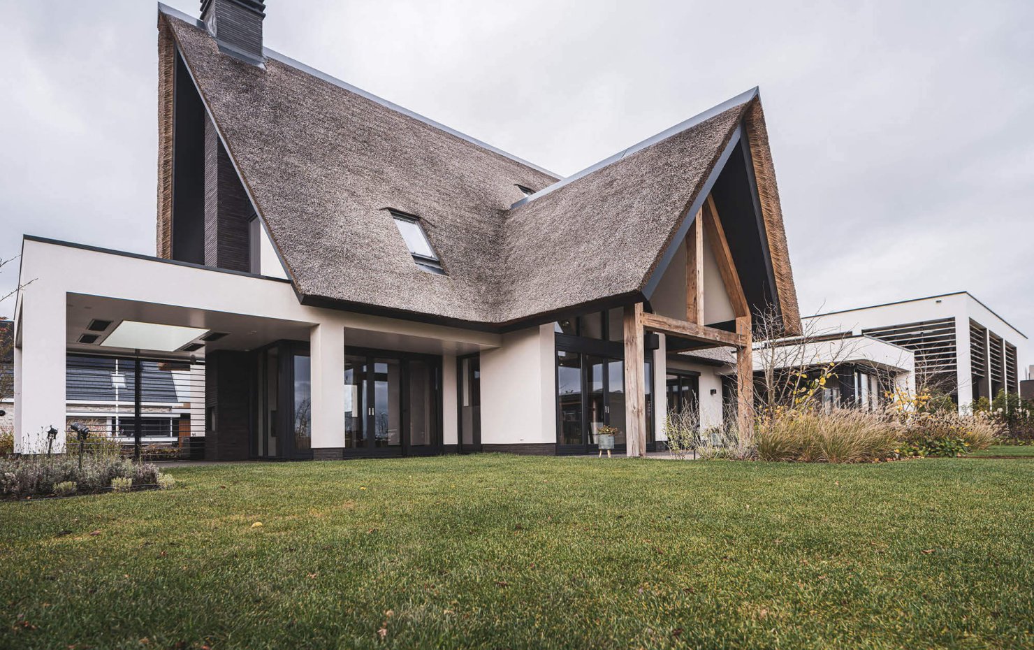 Landelijke, wit gestucte villa met rieten dak en veel grote ramen