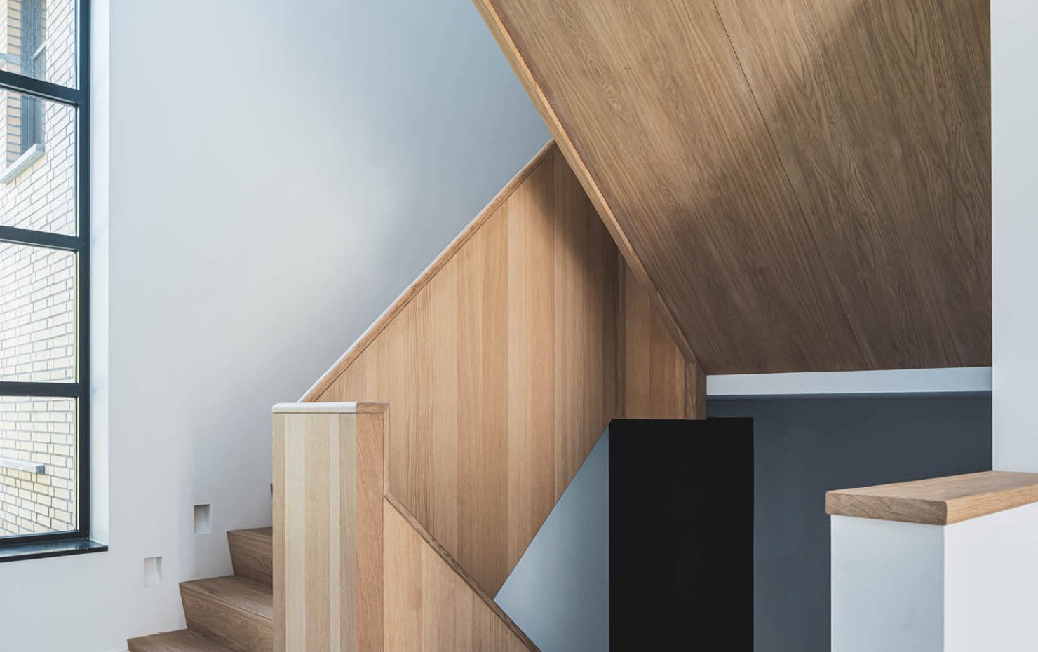 Witte gang met licht houten trappenhuis