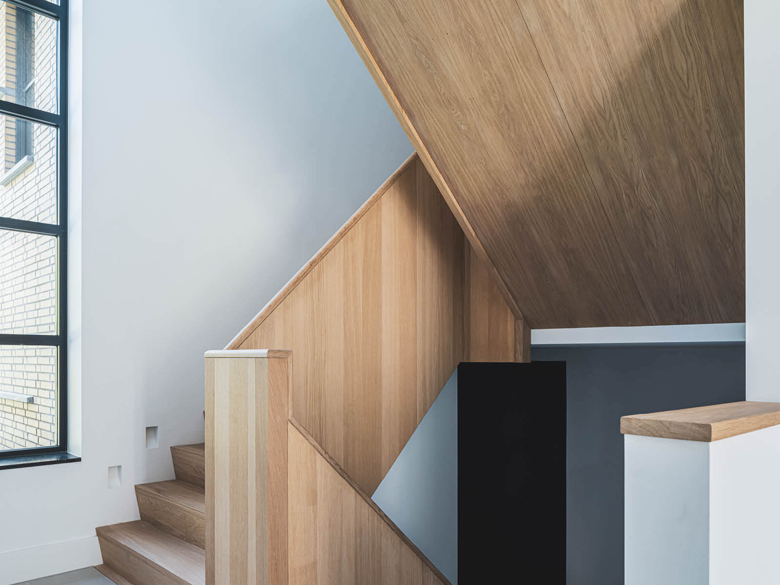Witte gang met licht houten trappenhuis