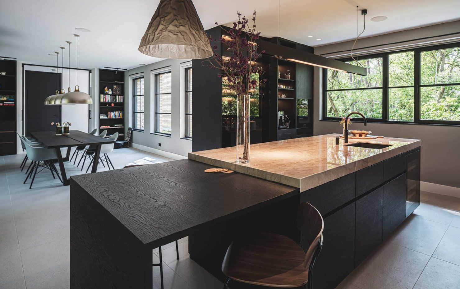 Moderne keuken en eetkamer met groot kookeiland in villa in Dukokstijl