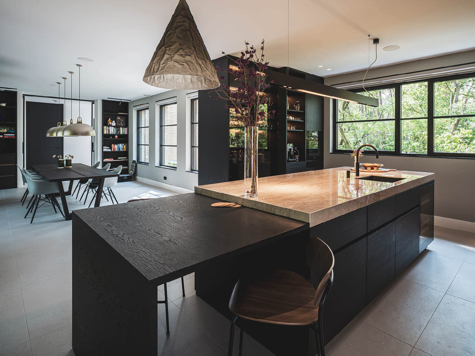 Moderne keuken en eetkamer met groot kookeiland in villa in Dukokstijl