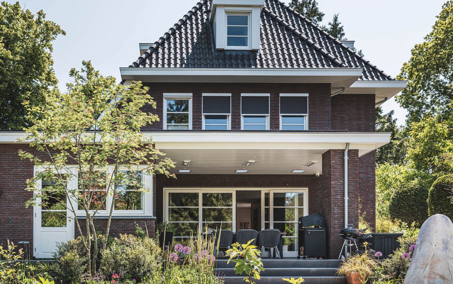 Stijlvolle jaren 30 woning met aangelegde tuin vol bloemen