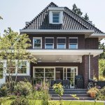 ThumbnailStijlvolle jaren 30 woning met aangelegde tuin vol bloemen