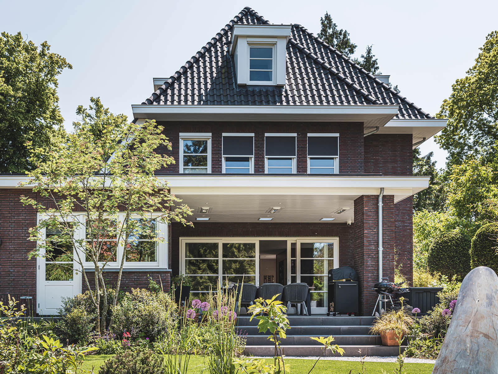 Stijlvolle jaren 30 woning met aangelegde tuin vol bloemen