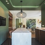 ThumbnailGroene keuken met hoge barretje, met op de achtergrond de eettafel