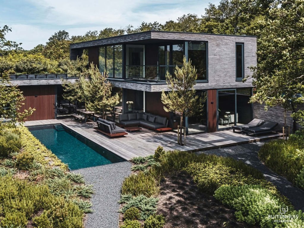 ThumbnailBovenaanzicht moderne kubistische villa met houten gevel, zwembad, terras, en omringd door groen
