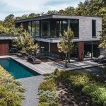ThumbnailBovenaanzicht moderne kubistische villa met houten gevel, zwembad, terras, en omringd door groen